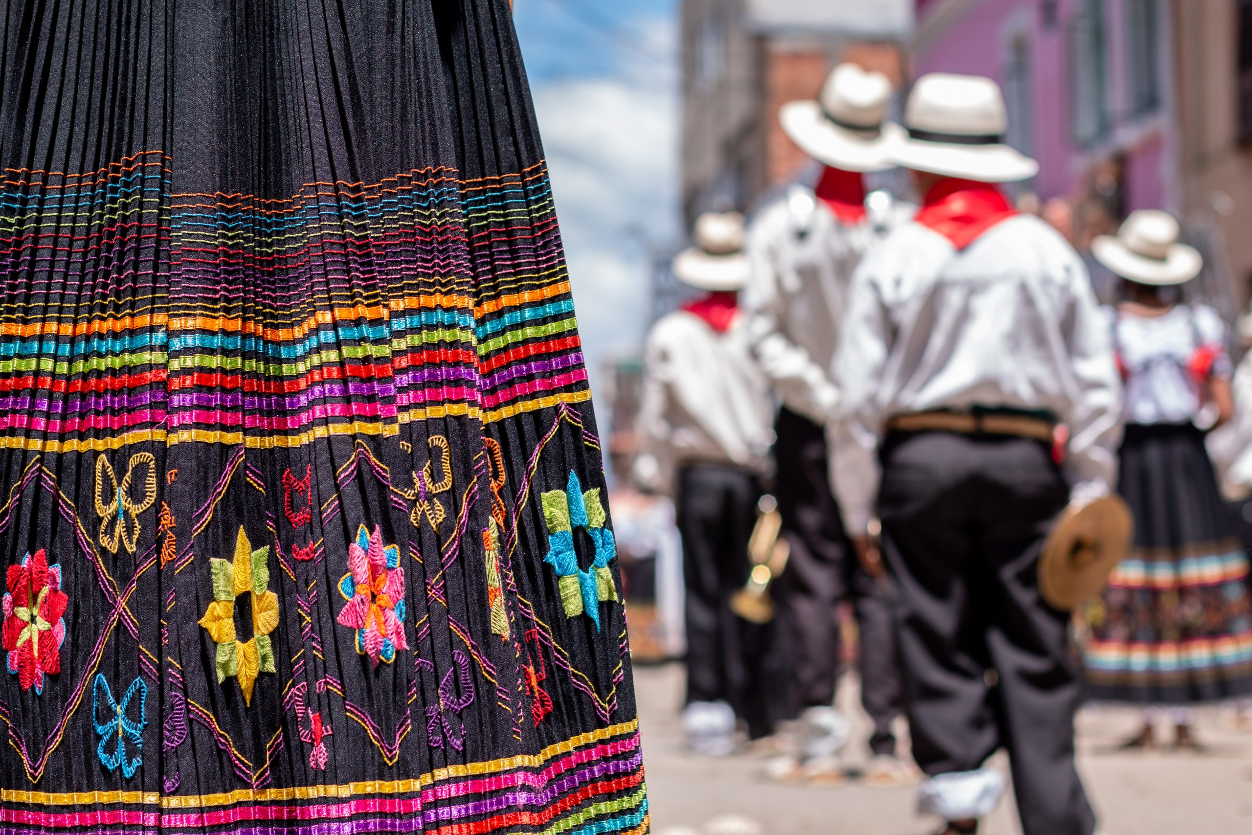 Typical colorful carnival skirt with decorations. Out of focus background of Latin American carnival Typical colorful carnival skirt with decorations. Close-up of a colorful women's costume and in the background a Latin American carnival parade.